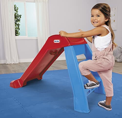 A happy child playing on the Little Tikes Slide.